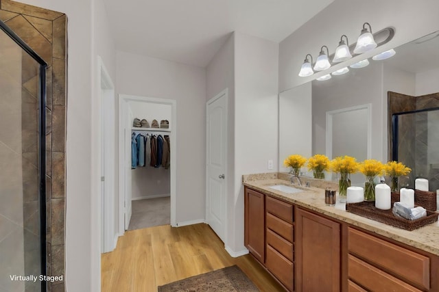 5928 Pescia St, Round Rock, TX 78665 - full bathroom with wood finished floors, a shower stall, vanity, and a walk in closet