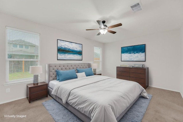 bedroom featuring light colored carpet, baseboards, and a ceiling fan