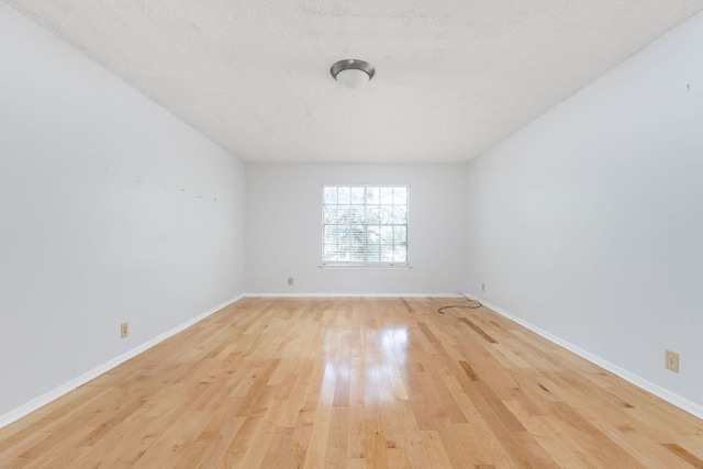 4007 Edgerock Dr, Austin, TX 78731 - unfurnished room with light wood-style floors, baseboards, and a textured ceiling