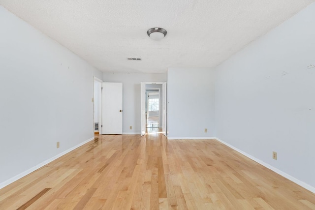 4007 Edgerock Dr, Austin, TX 78731 - unfurnished room with light wood finished floors, a textured ceiling, and baseboards