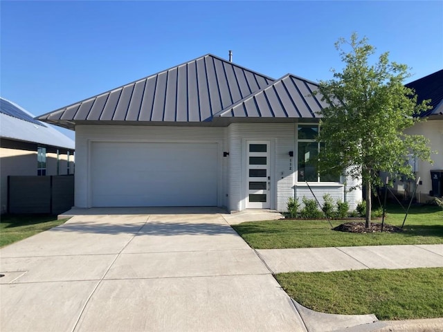 112 Rough Creek Rd, Georgetown, TX 78628 - view of front of property with a standing seam roof, metal roof, a garage, concrete driveway, and a front lawn