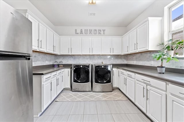 1513 Burr Pkwy, Leander, TX 78641 - laundry room featuring independent washer and dryer, cabinet space, and light tile patterned flooring