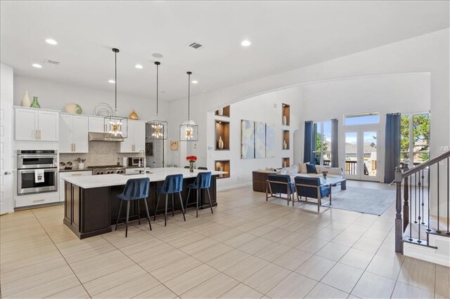 1513 Burr Pkwy, Leander, TX 78641 - kitchen with stainless steel double oven, a sink, light countertops, open floor plan, and a spacious island