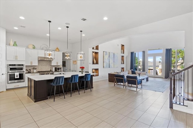 1513 Burr Pkwy, Leander, TX 78641 - kitchen with double oven, light countertops, open floor plan, a large island with sink, and a kitchen breakfast bar