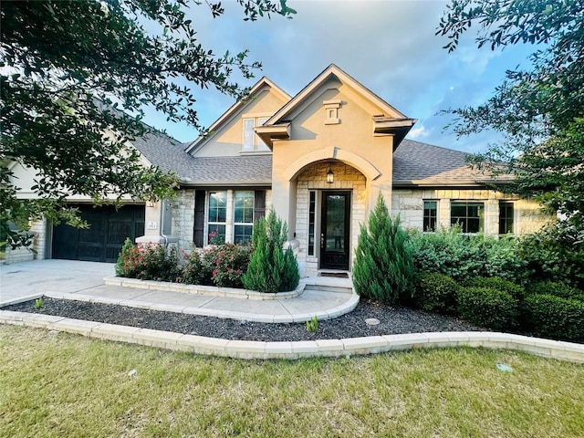 1513 Burr Pkwy, Leander, TX 78641 - traditional-style home featuring stone siding, an attached garage, roof with shingles, concrete driveway, and a front lawn
