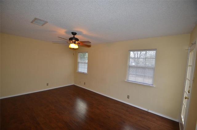 spare room with a textured ceiling, a ceiling fan, wood finished floors, and baseboards