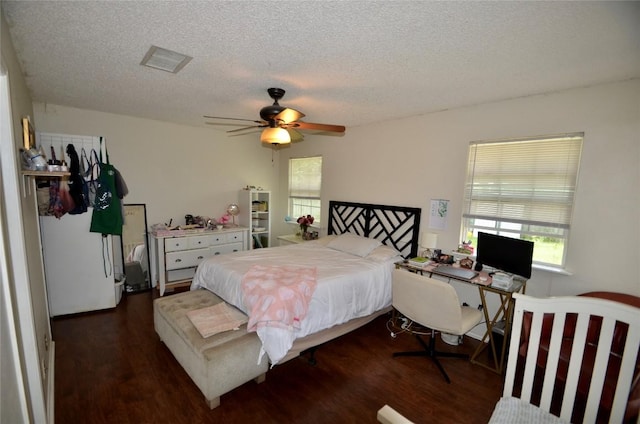 bedroom featuring dark wood-type flooring, a textured ceiling, and ceiling fan