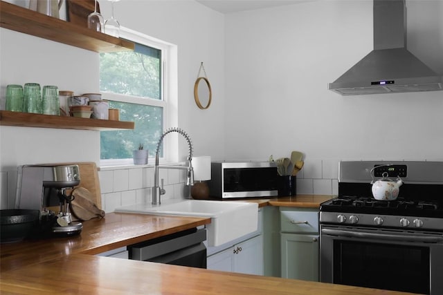 4906 Hilldale Dr, Austin, TX 78723 - kitchen featuring stainless steel appliances, wall chimney exhaust hood, backsplash, and healthy amount of natural light