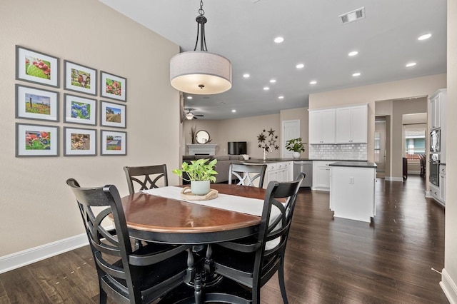 dining room featuring dark wood-style flooring, recessed lighting, baseboards, ceiling fan, and a fireplace