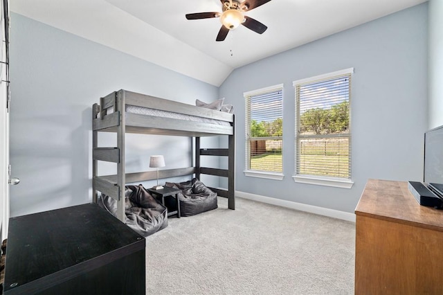 bedroom featuring carpet, baseboards, vaulted ceiling, and a ceiling fan
