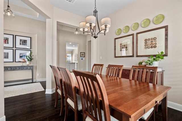 dining room featuring a chandelier, dark wood-style flooring, and baseboards