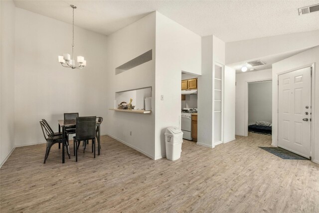 515 Sierra Cv, Round Rock, TX 78664 - dining space with light wood finished floors, a chandelier, baseboards, and high vaulted ceiling