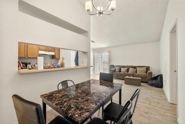 515 Sierra Cv, Round Rock, TX 78664 - dining space featuring a chandelier, light wood finished floors, high vaulted ceiling, and baseboards