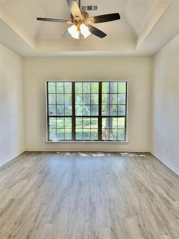 1816 Lancaster St, San Marcos, TX 78666 - unfurnished room featuring a tray ceiling, wood finished floors, a ceiling fan, lofted ceiling, and baseboards