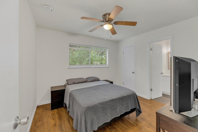 9811 Hansford Dr, Austin, TX 78753 - bedroom with wood finished floors, baseboards, ceiling fan, and ensuite bath
