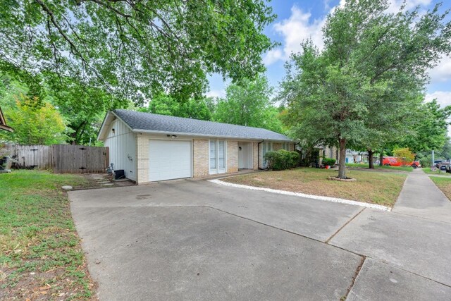 9811 Hansford Dr, Austin, TX 78753 - single story home featuring driveway, an attached garage, brick siding, fence, and a shingled roof