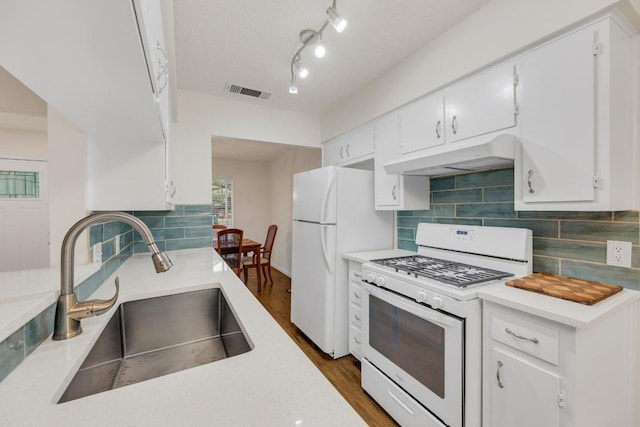9811 Hansford Dr, Austin, TX 78753 - kitchen with white appliances, a sink, under cabinet range hood, backsplash, and white cabinetry