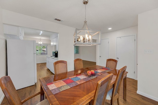 9811 Hansford Dr, Austin, TX 78753 - dining space with a chandelier, wood finished floors, baseboards, and recessed lighting