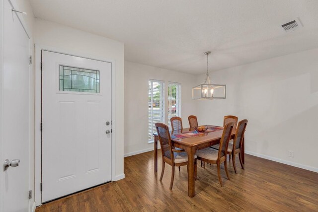 9811 Hansford Dr, Austin, TX 78753 - dining space featuring a chandelier, baseboards, and wood finished floors