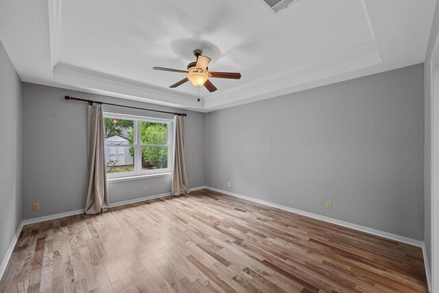 1013 Pecan Creek Dr, Pflugerville, TX 78660 - unfurnished room featuring a raised ceiling, ceiling fan, light wood-style flooring, ornamental molding, and baseboards