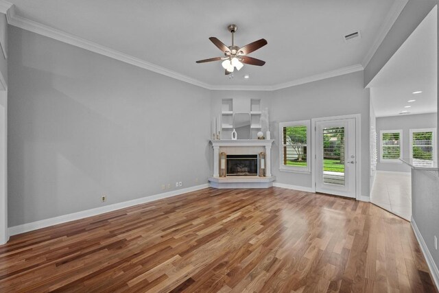 1013 Pecan Creek Dr, Pflugerville, TX 78660 - unfurnished living room featuring a ceiling fan, wood finished floors, ornamental molding, baseboards, and a glass covered fireplace
