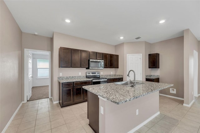 625 Taggart Trl, Jarrell, TX 76537 - kitchen with stainless steel appliances, a sink, dark brown cabinets, baseboards, and light tile patterned flooring