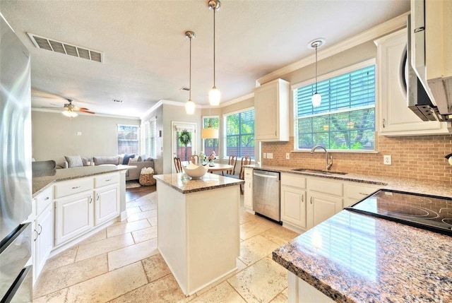 11805 Lake Stone Dr, Austin, TX 78738 - kitchen featuring appliances with stainless steel finishes, a sink, decorative backsplash, crown molding, and stone counters