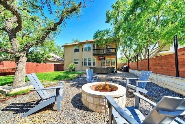 11805 Lake Stone Dr, Austin, TX 78738 - rear view of house with an outdoor fire pit, a hot tub, a patio area, a balcony, and stucco siding
