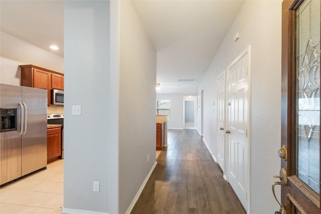 hall featuring baseboards and light wood finished floors