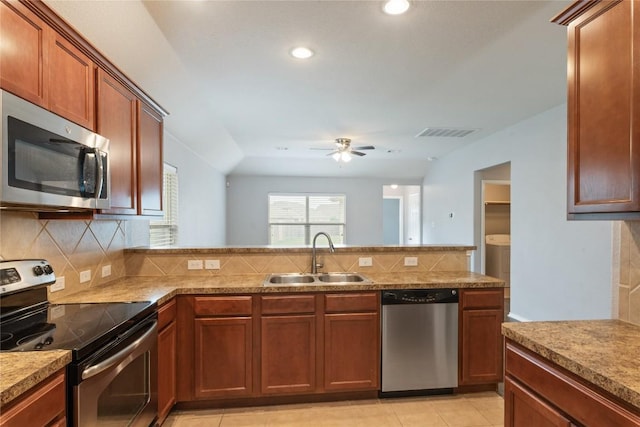 kitchen with stainless steel appliances, a sink, tasteful backsplash, a peninsula, and a ceiling fan