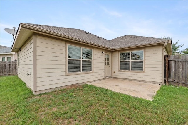 rear view of property with a patio area and roof with shingles