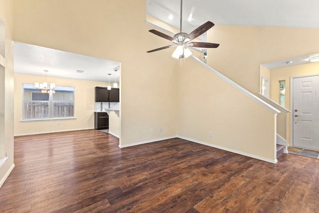 9216 Vigen Cir, Austin, TX 78748 - unfurnished living room featuring a chandelier, dark wood-style flooring, stairway, a ceiling fan, and a high ceiling