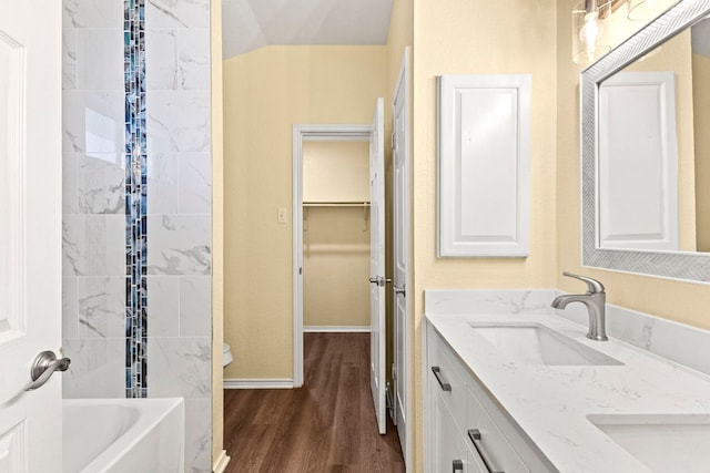 9216 Vigen Cir, Austin, TX 78748 - full bathroom with double vanity, wood finished floors, baseboards, and shower / washtub combination