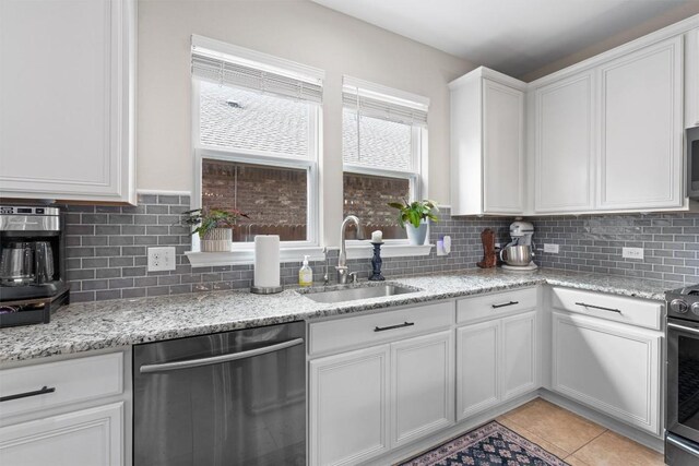 8058 Arezzo Dr, Round Rock, TX 78665 - kitchen featuring stainless steel appliances, decorative backsplash, white cabinetry, and light tile patterned floors