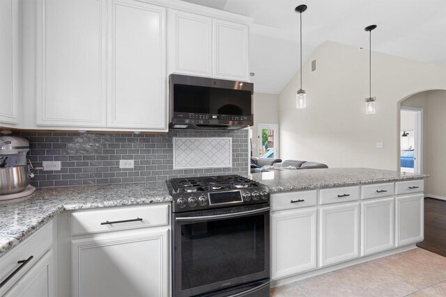 8058 Arezzo Dr, Round Rock, TX 78665 - kitchen with appliances with stainless steel finishes, arched walkways, tasteful backsplash, white cabinetry, and vaulted ceiling