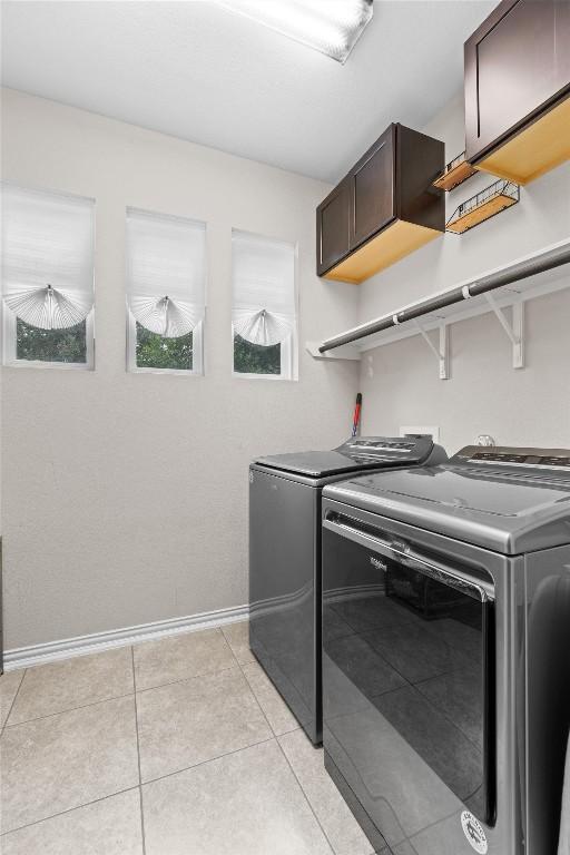 8058 Arezzo Dr, Round Rock, TX 78665 - laundry room featuring cabinet space, washer and dryer, and light tile patterned floors