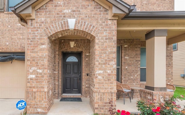 316 Carrington St, Hutto, TX 78634 - property entrance featuring brick siding, a garage, and a porch