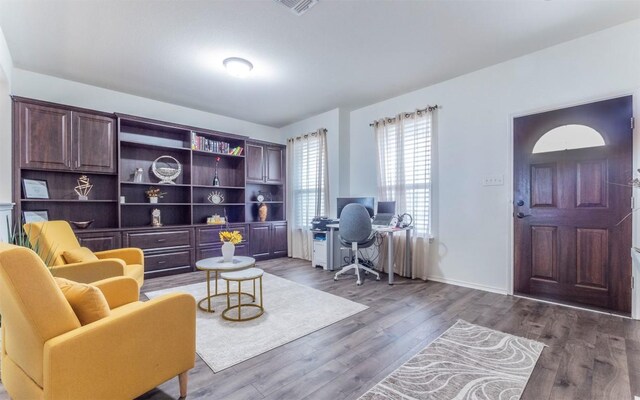 sitting room featuring a desk, wood finished floors, and baseboards