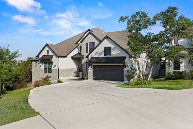 321 Cumberland Cv, Georgetown, TX 78628 - view of front of house featuring stucco siding, driveway, a standing seam roof, and a shingled roof