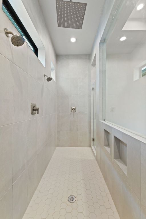 321 Cumberland Cv, Georgetown, TX 78628 - bathroom featuring tiled shower, recessed lighting, and healthy amount of natural light