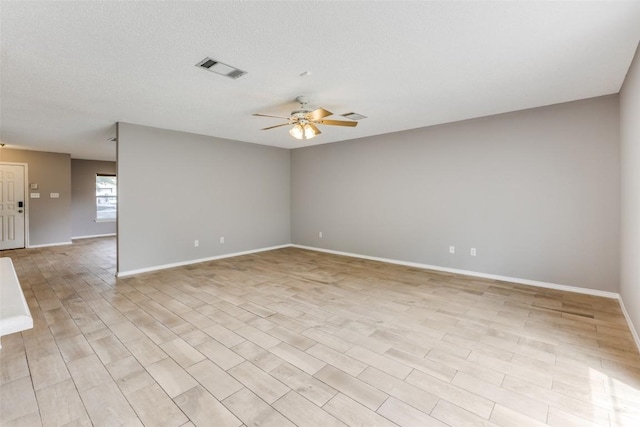 spare room with a ceiling fan and baseboards