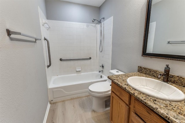 full bathroom with toilet, shower / bathtub combination, vanity, a textured wall, and wood finished floors
