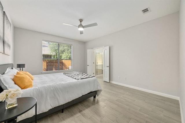 bedroom featuring baseboards, wood finished floors, a ceiling fan, and connected bathroom