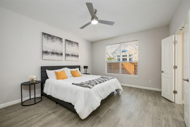 bedroom with wood finished floors, baseboards, and a ceiling fan