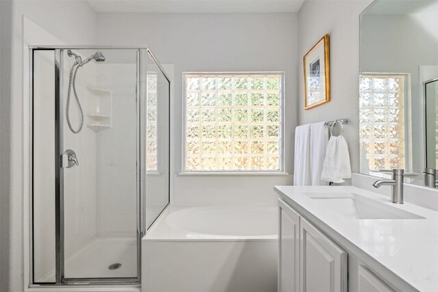 bathroom with a shower stall, vanity, and a bath