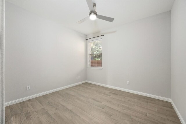 empty room with light wood-style floors, a ceiling fan, and baseboards