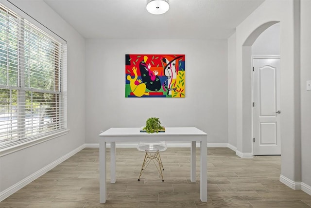 office featuring arched walkways, wood finished floors, and baseboards