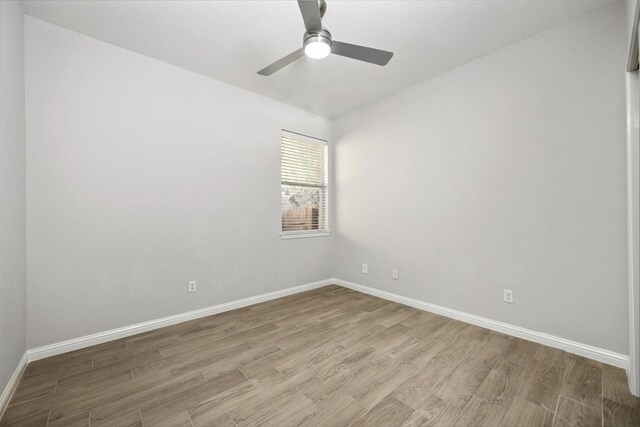 empty room featuring wood finished floors, baseboards, and ceiling fan