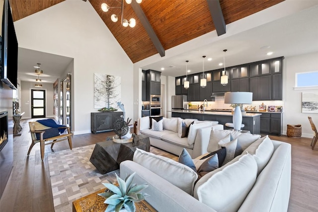 217 Northcrest Dr, Liberty Hill, TX 78642 - living room with high vaulted ceiling, wood ceiling with exposed beams, wood finished floors, a chandelier, and baseboards