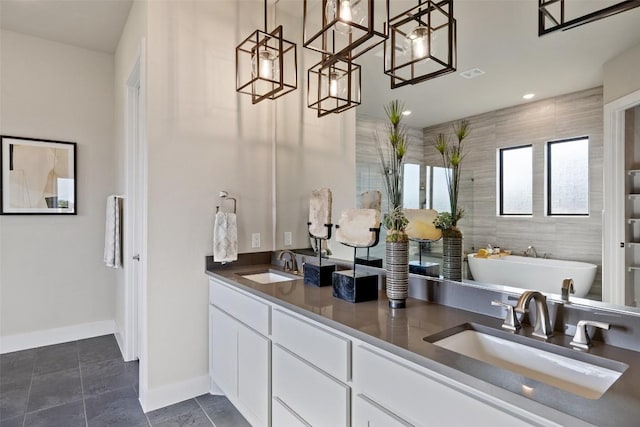 217 Northcrest Dr, Liberty Hill, TX 78642 - bathroom with a freestanding tub, double vanity, baseboards, and recessed lighting